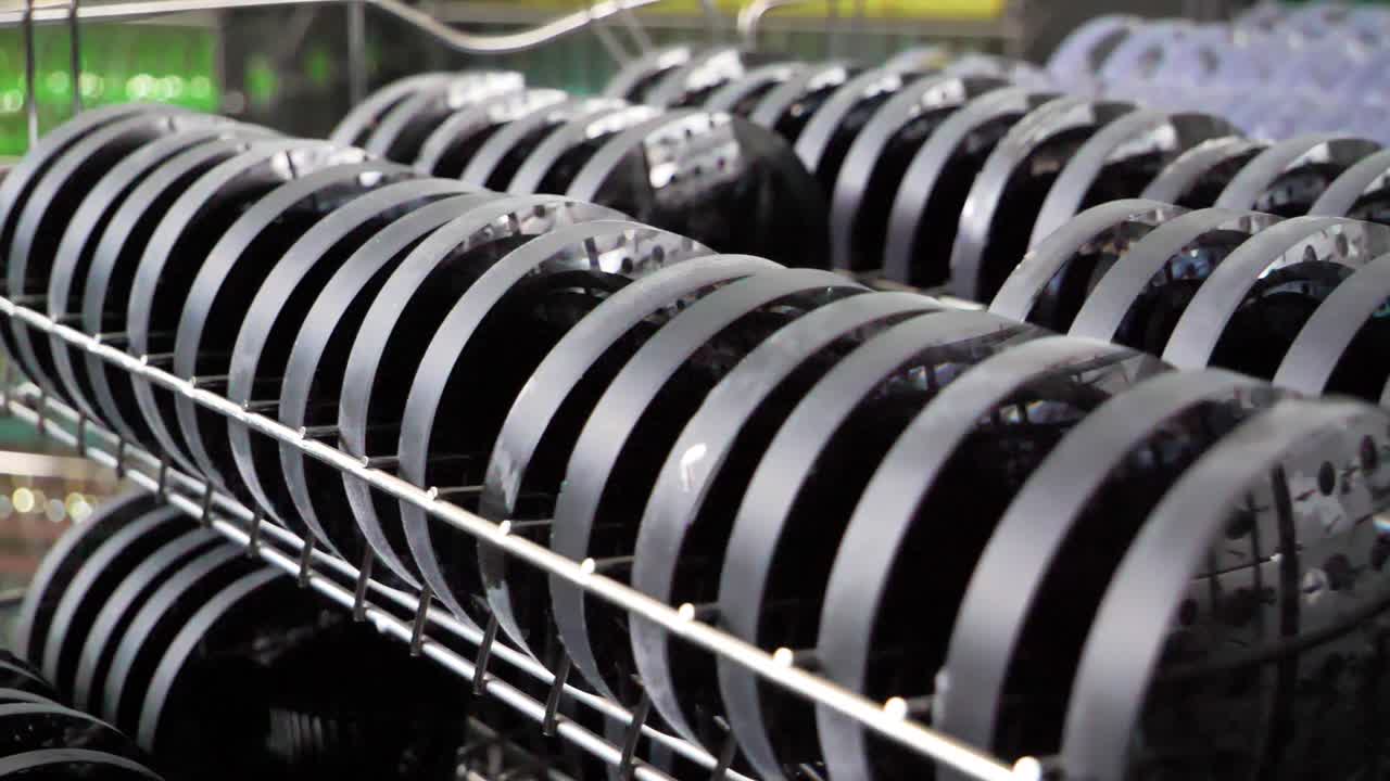 Rows of Black Circular Parts on a Metal Rack