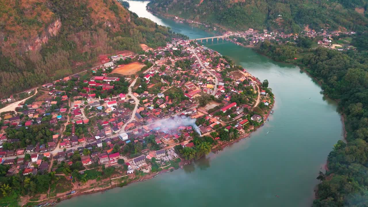 vista aérea de nong khiaw, laos, con un río que fluye a través de un pueblo rodeado de colinas