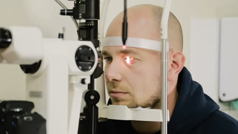 adopting an ophthalmologist. man doing eye test with optometrist in medical office