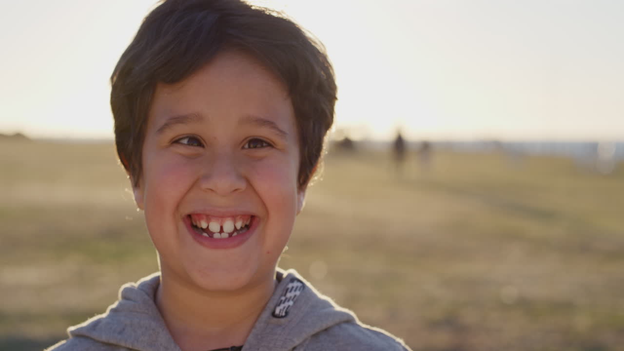 retrato em close-up de um menino hispânico feliz a brincar, a fazer caras engraçadas, a desfrutar de um dia ensolarado no parque à beira-mar