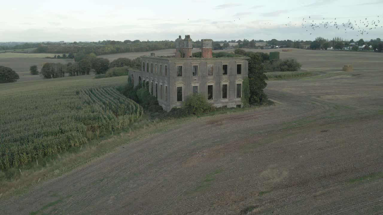 Drone footage of an abandoned stone house in a cornfield
