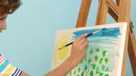 smiling boy painting his picture