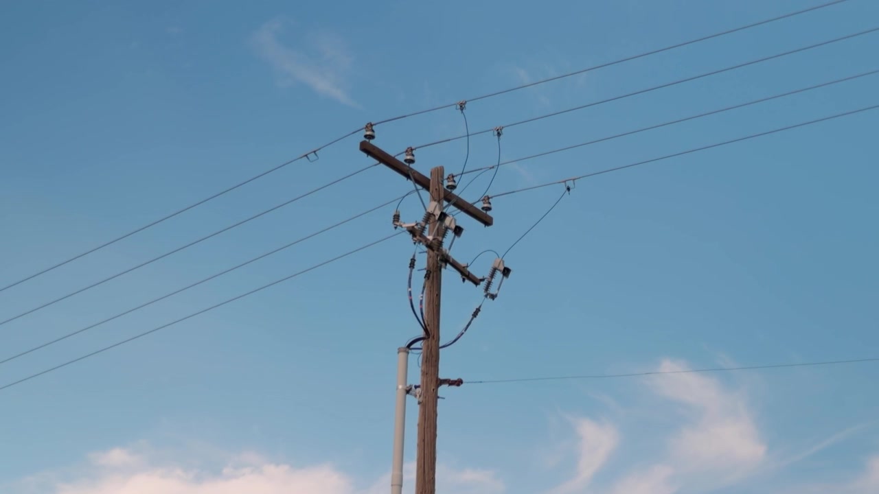 Steady forward tracking shot approaching a wooden utility pole.