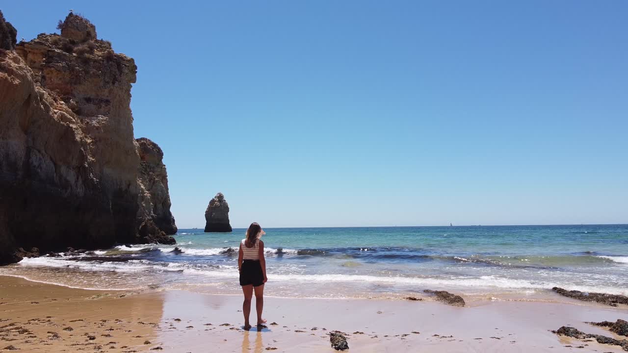 playa praia dos tres irmaos, algarve, portugal - chica turista caminando en la playa de arena a través del mar azul claro