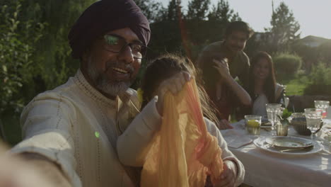 indian family gathering outdoors for a meal at sunset