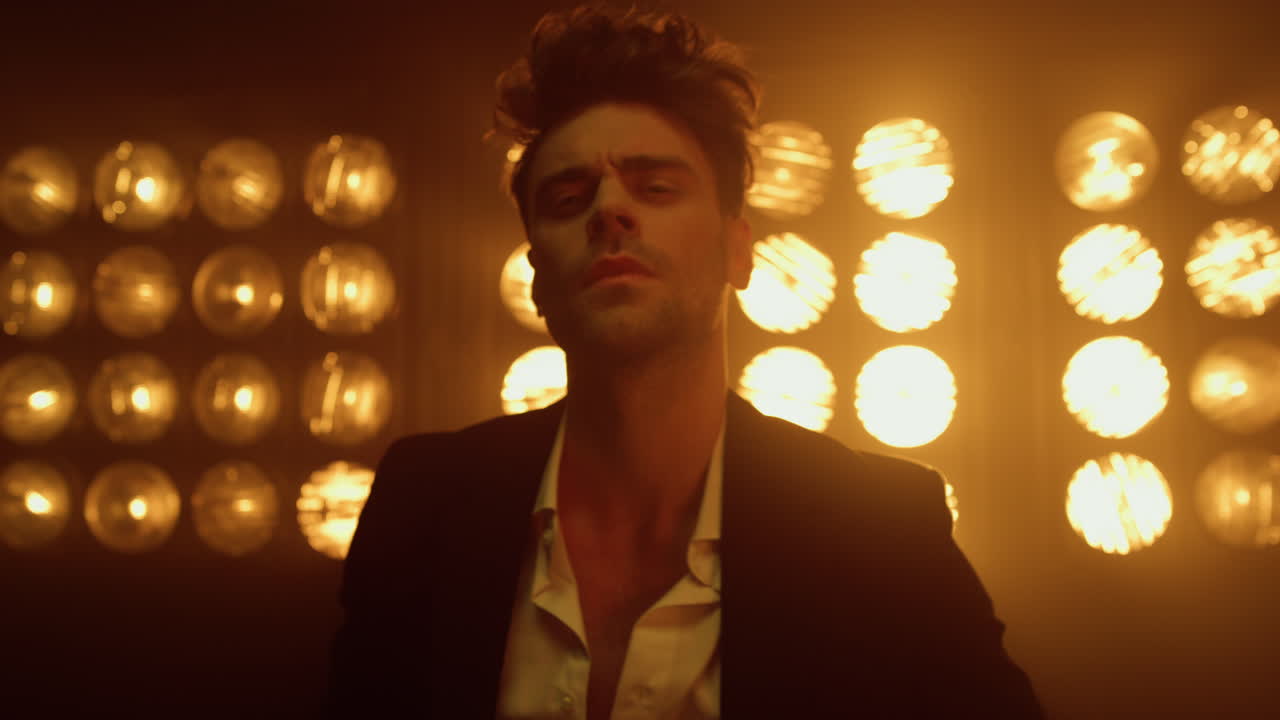 hombre encantador posando profesionalmente iluminado lámparas de club. retrato chico guapo