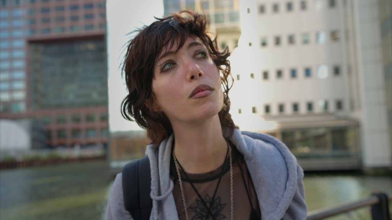 retrato de moda al aire libre de una mujer joven de estilo alternativo con tatuajes y piercings en canary wharf en los muelles de londres filmado en tiempo real 5