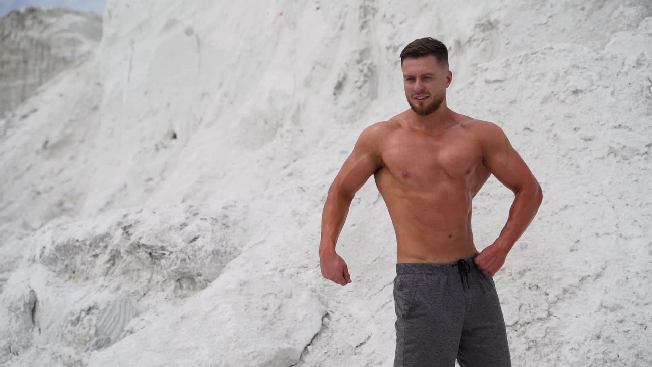 Athletic man standing with naked torso. Strong sportsman with naked torso showing muscular body