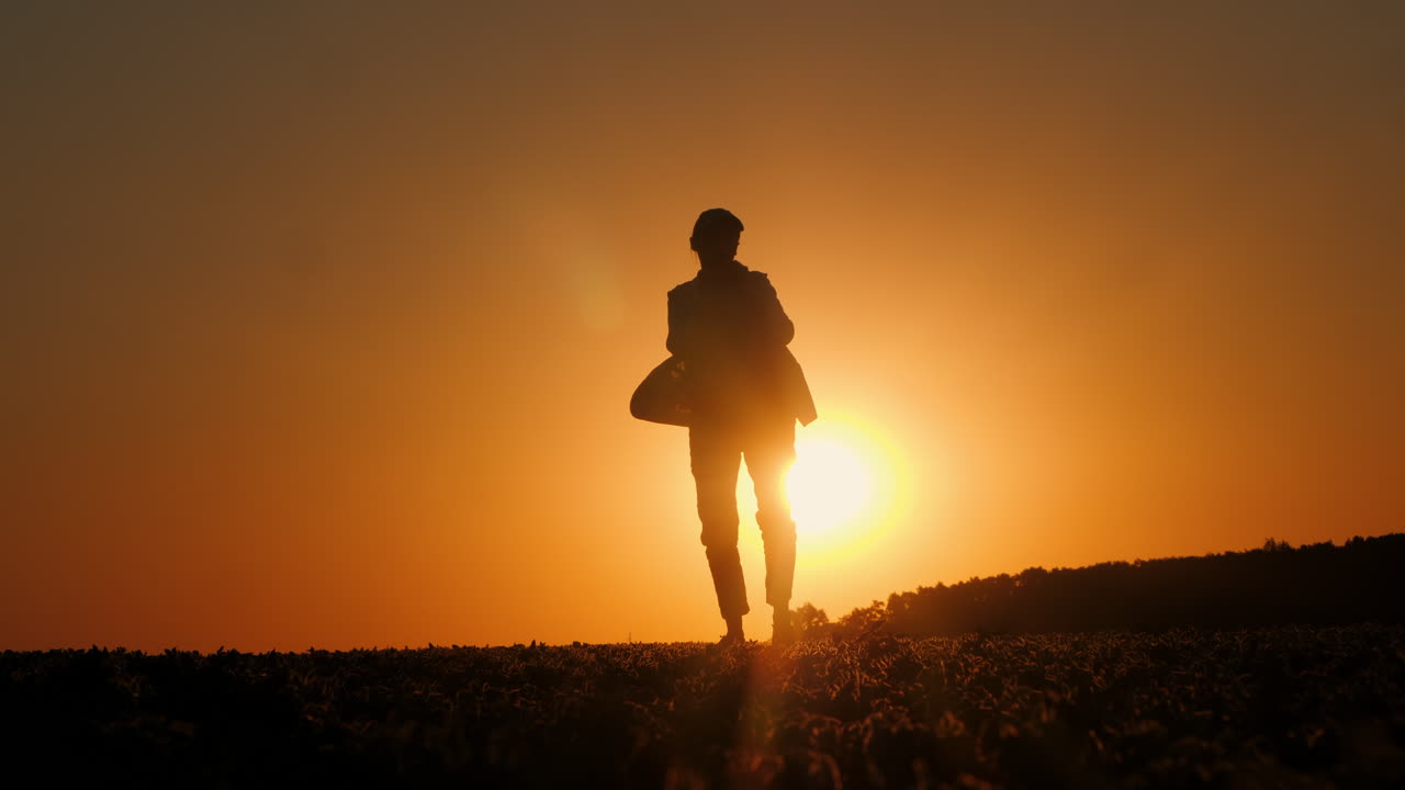 silueta de una mujer caminando al atardecer