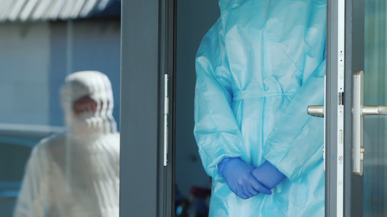 보호복을 입은 택배가 의사에게 귀중품이 든 빨간 상자를 건네준다 1