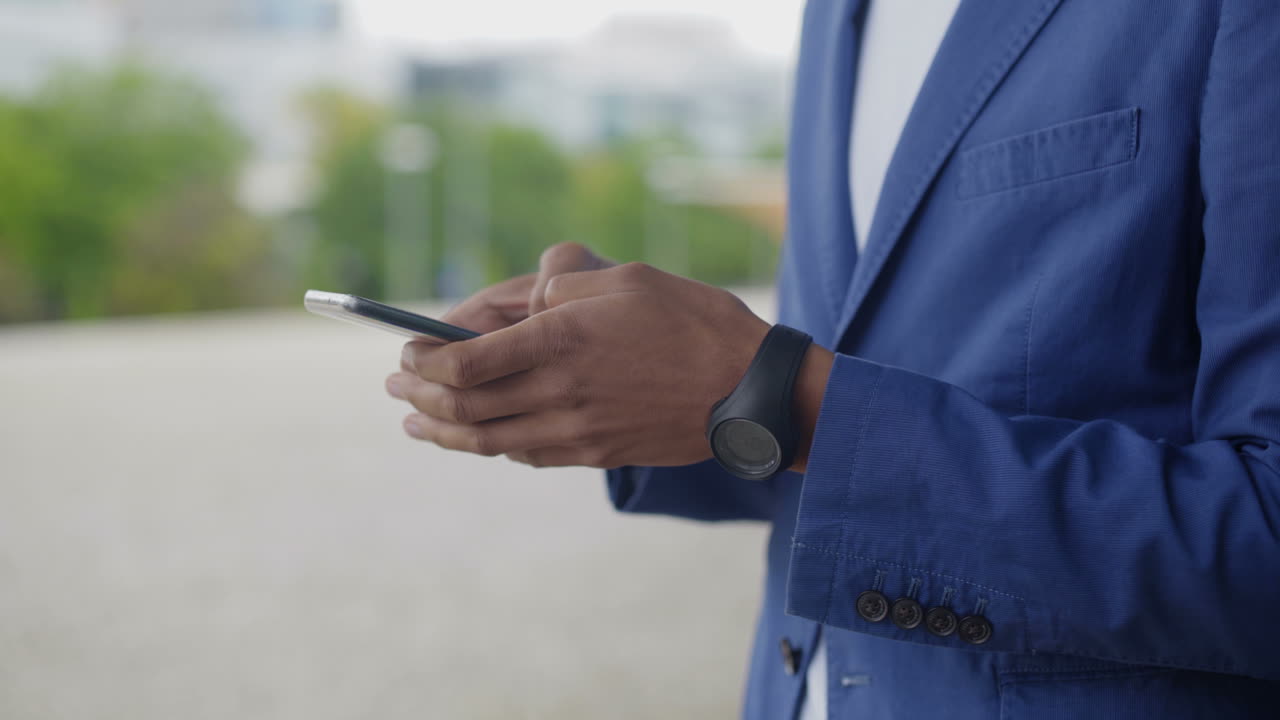 Cropped shot of young man typing message on smartphone.