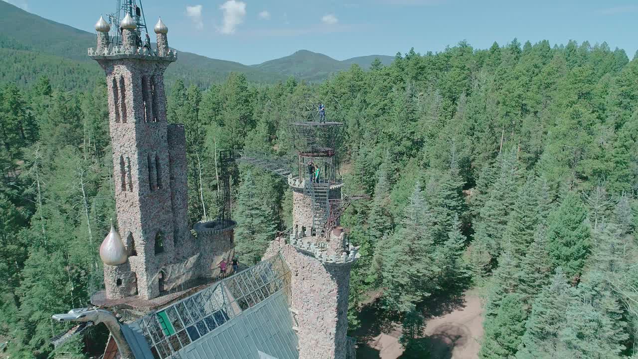 вид с беспилотника на здание, похожее на замок, посреди леса в колорадо