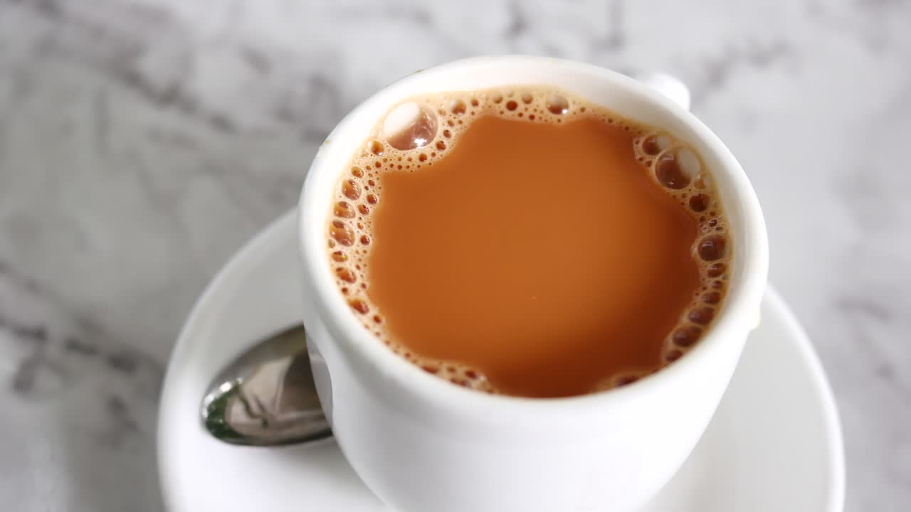 cerrar una taza de té con leche en la mesa,