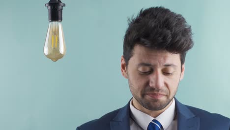 Businessman-looking-at-idea-lamp-and-trying-to-come-up-with-ideas.