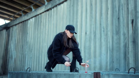 Girl-lighting-smoke-grenade-on-street.-Lady-holding-sparkling-smoke-bomb-in-hand