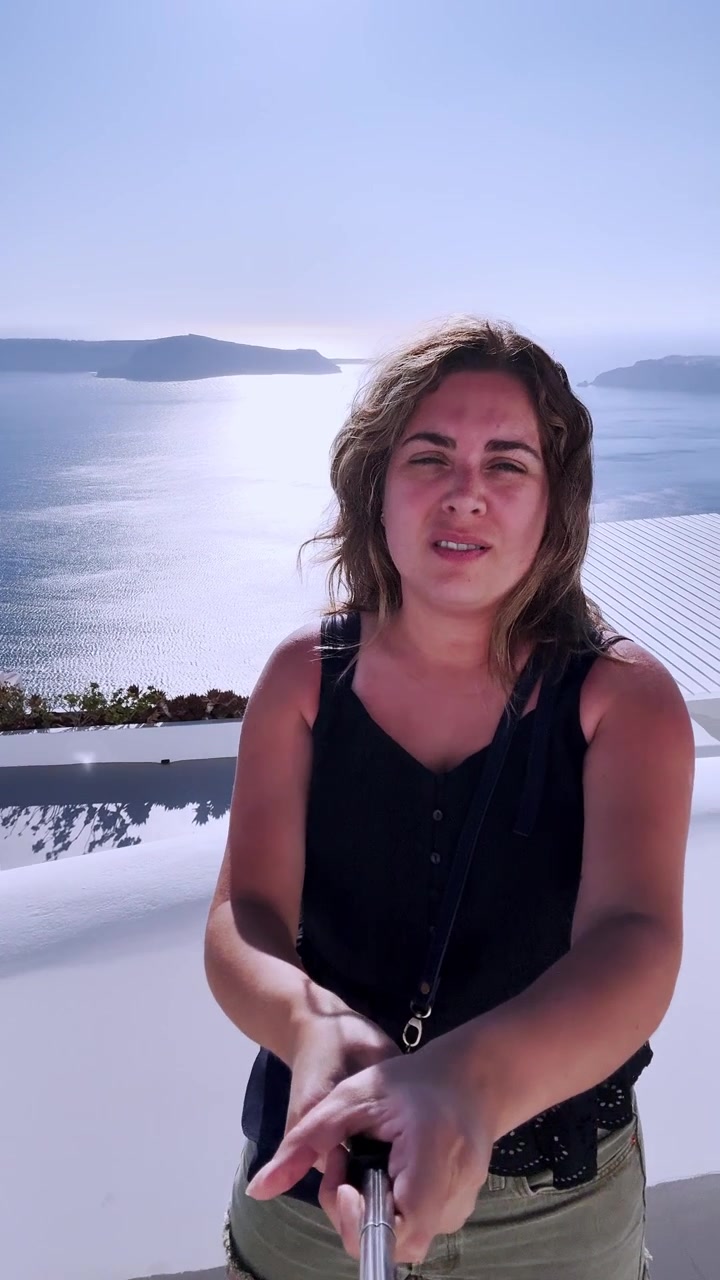Kvinde laver duckface på vlogging-ferie på Santorini