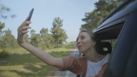 Chica-Tomando-Selfie-A-Través-De-La-Ventana-Abierta-Del-Auto