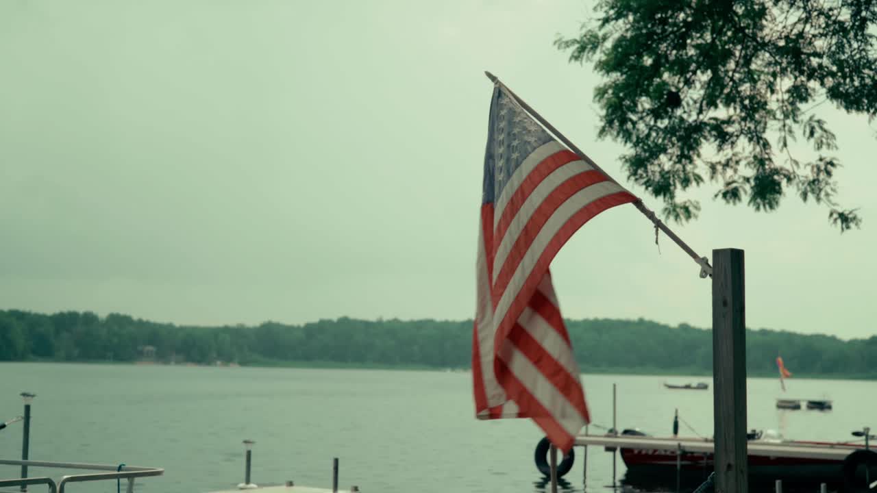 bandera estadounidense sobre un lago soplando en el viento