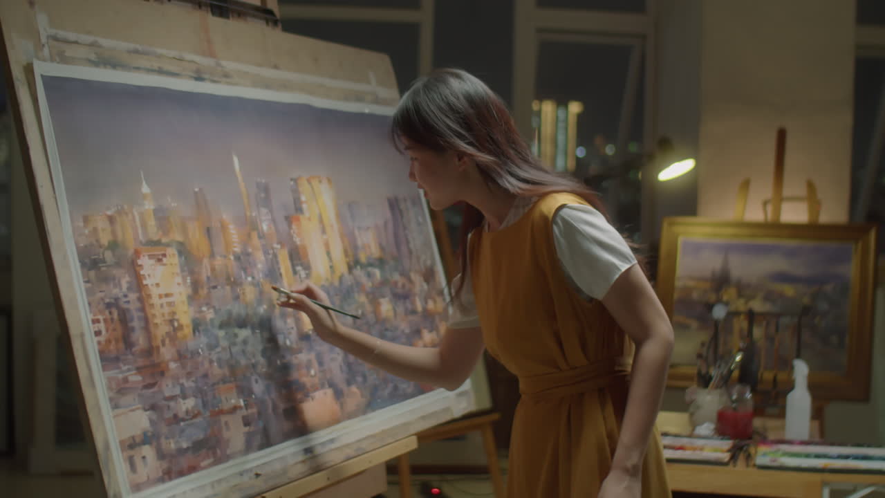 Female Artist Painting Night City Panorama in Studio