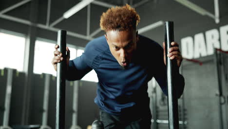 man doing sled push exercise at the gym