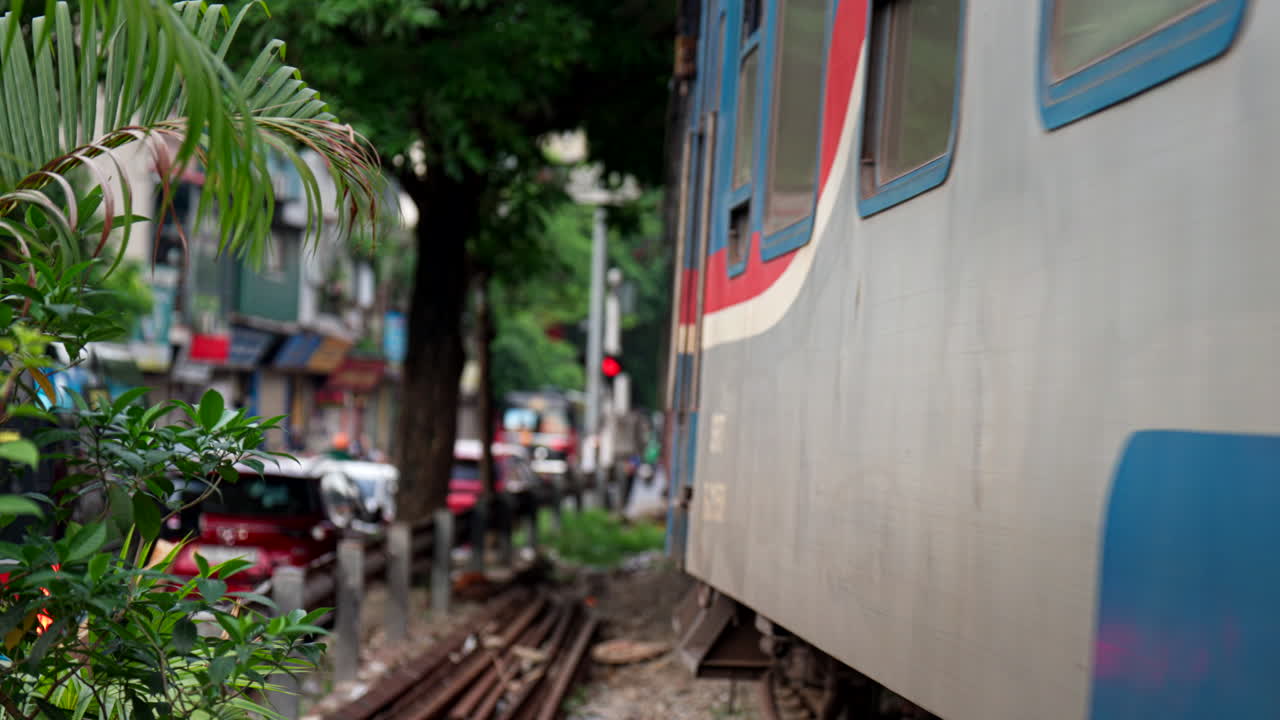 Train passing through a busy city street in Vietnam