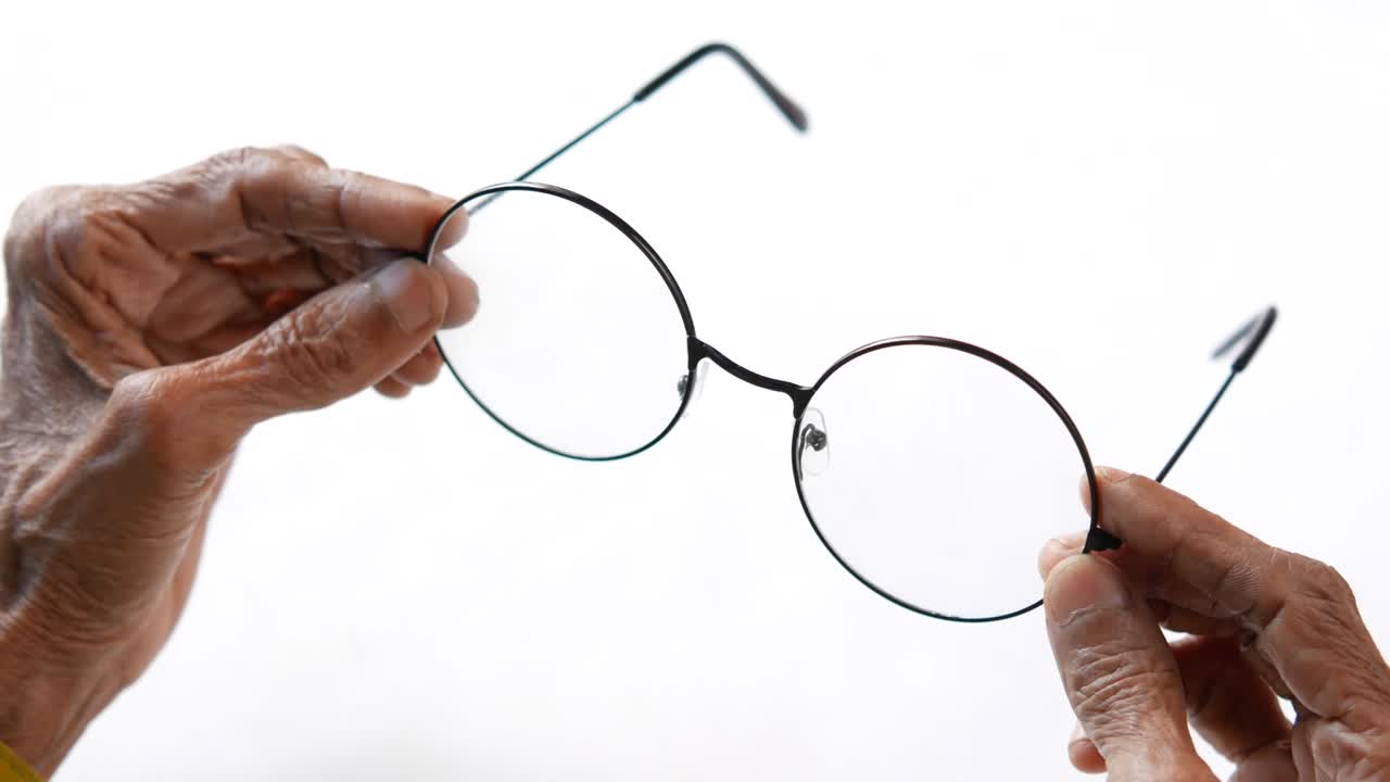 close up de mujeres mayores con la mano sosteniendo gafas viejas