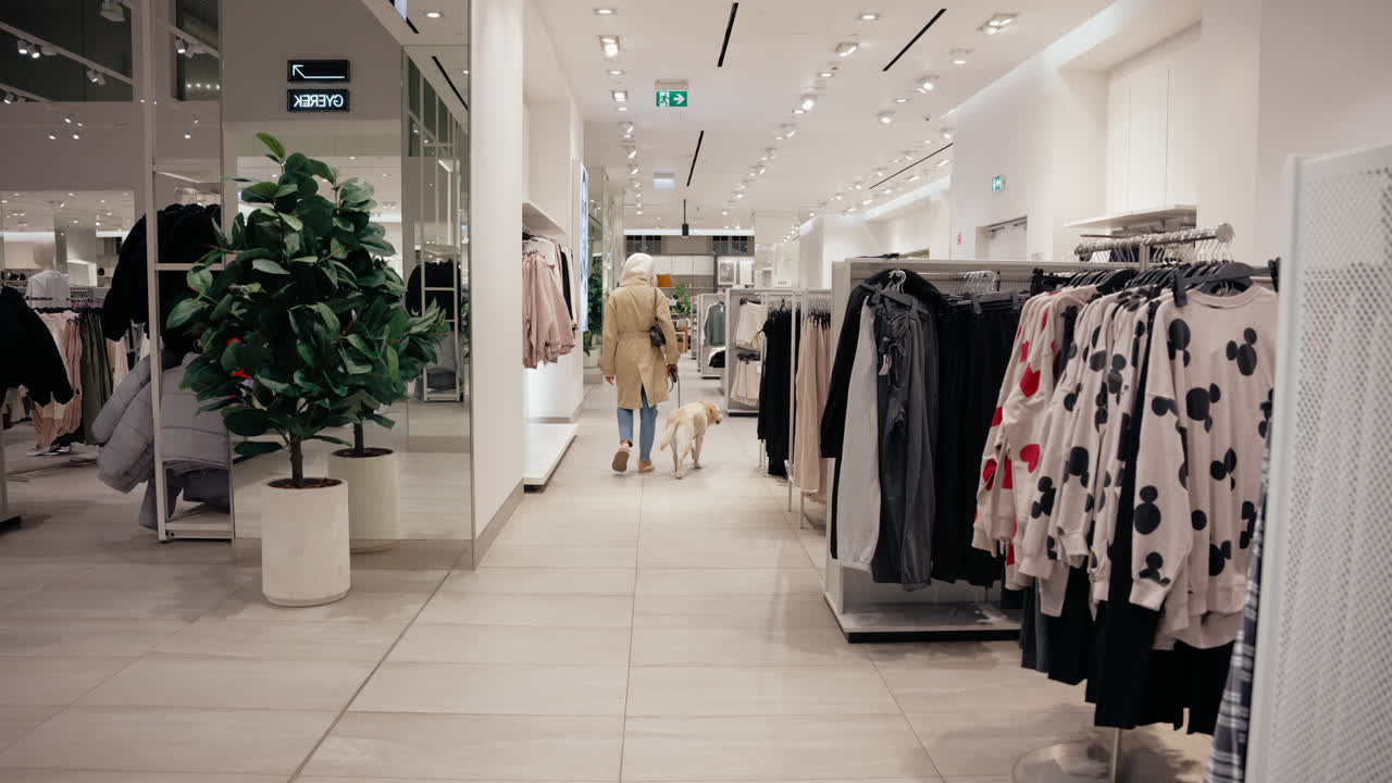 la madre del perro hipster está de compras con su adorable labrador amarillo en una tienda de ropa amigable con mascotas en budapest.