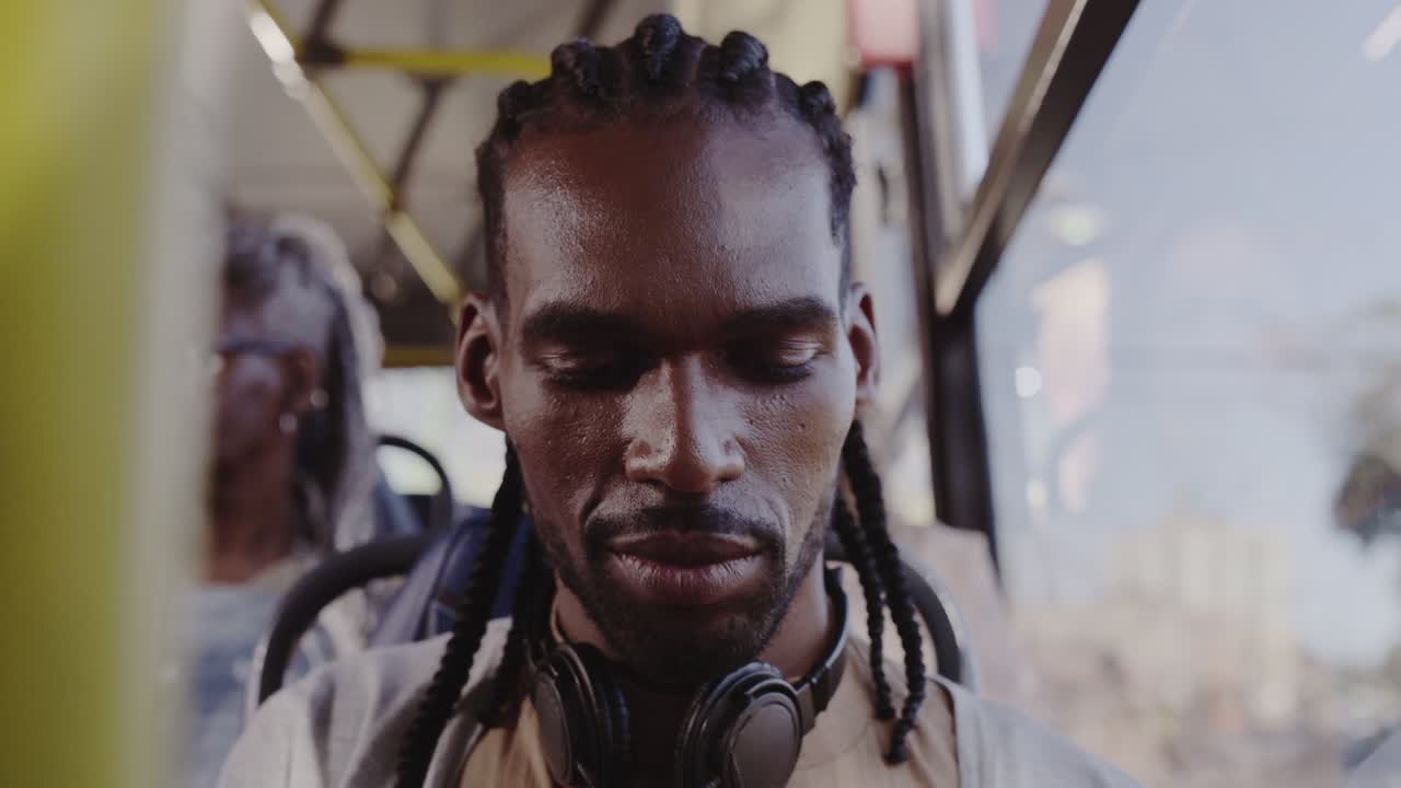 A man with dreadlocks commutes on a bus