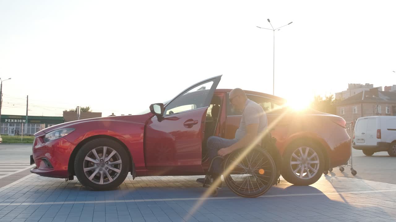 체어 에 앉은 장애인 이 슈퍼마켓 주차장 에서 자기 앞 에 바구니 를 밀고 있다