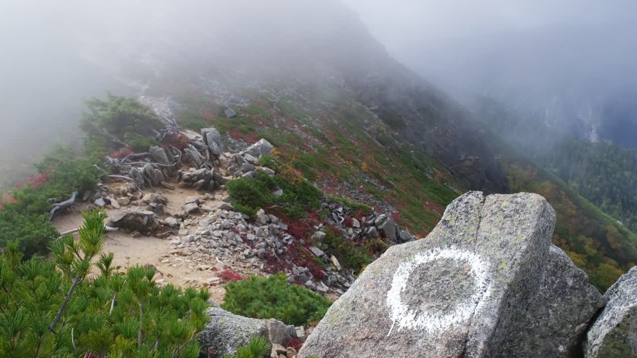 Khung cảnh thanh bình của Đường mòn Panorama Ginza ở Bắc Alps Nhật Bản. Phong cảnh mùa thu với sương mù, có một vạch đánh dấu đường mòn hình tròn màu trắng trên một tảng đá gồ ghề, dưới điều kiện ánh sáng dịu nhẹ