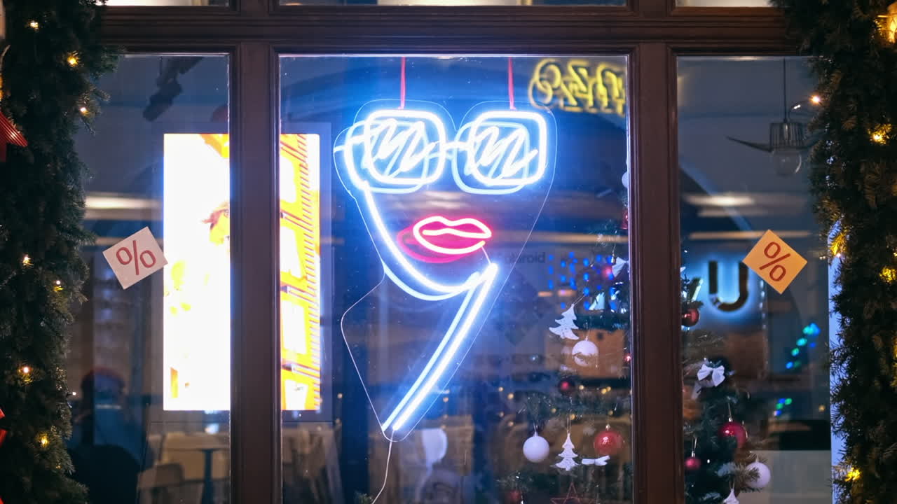Entrance of a shop at night. Glowing logo, Christmas decorations
