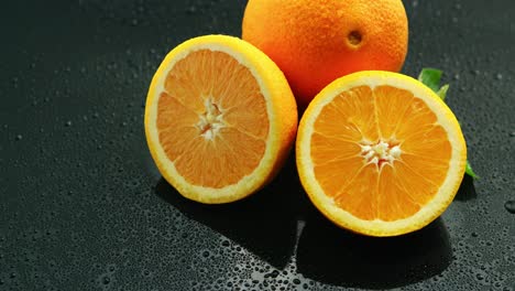 Orange-Mit-Blatt-Auf-Nassem-Tisch