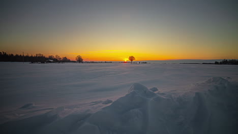 Toma-Amplia-De-Lapso-De-Tiempo-Del-Amanecer-Dorado-En-La-Iluminación-Del-Horizonte-En-El-Campo-De-Paisaje-Invernal-Blanco-Nevado