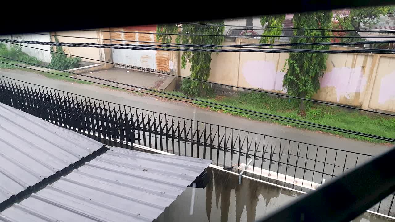 My view of the street from quarantine hotel facility window on a grey, rainy day during pandemic in capital Dili, Timor Leste, Southeast Asia