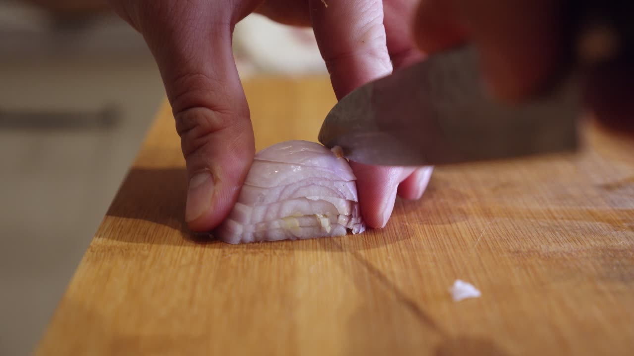 Slicing onion with sharp knife on a cut board