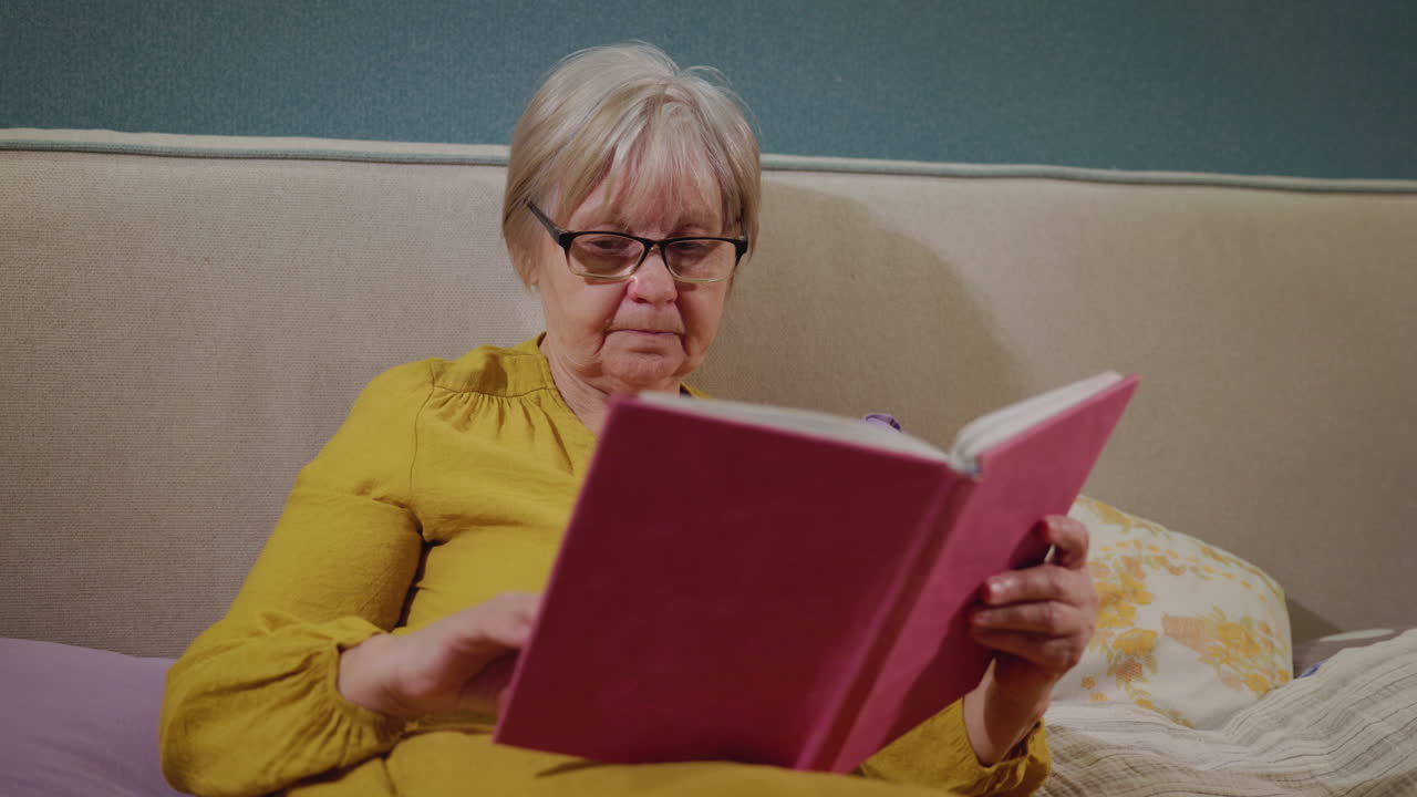 mujer mayor leyendo en la cama