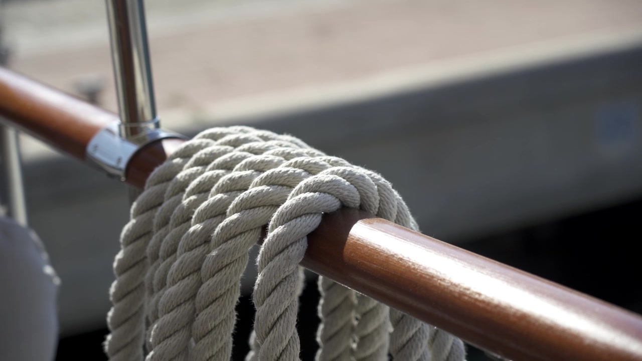 Corda avvolta attorno al corrimano di una barca pronta per essere assicurata al molo - primo piano isolato