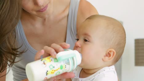 madre alimentando a su niña con un biberón