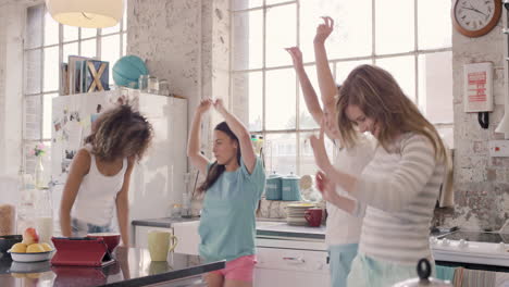 young group of girl friends  dancing in kitchen wearing pyjamas