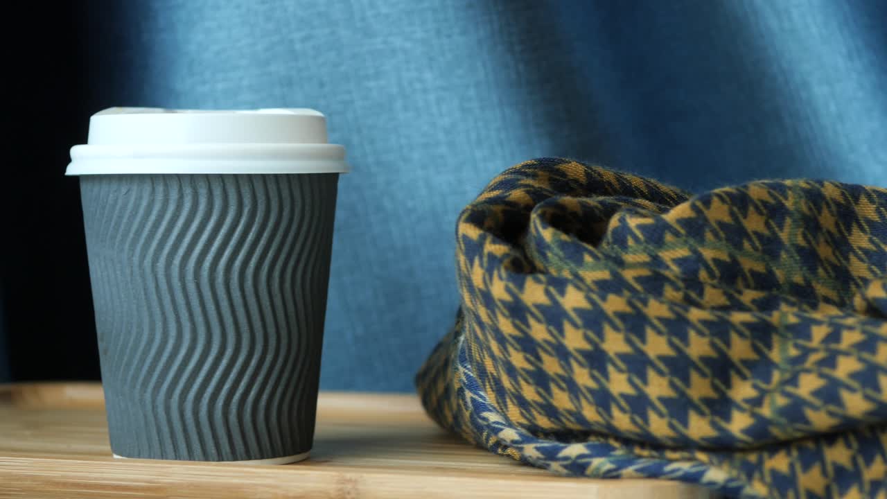 quita la taza de café de papel de la mesa de la cafetería .