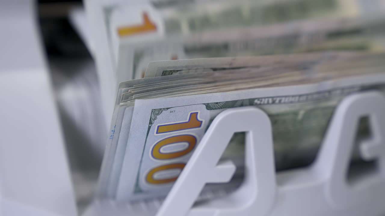 Paper cash money calculation. Electronic money counter machine is counting paper banknotes. Detailed view currency of hundred bills on counter machine.