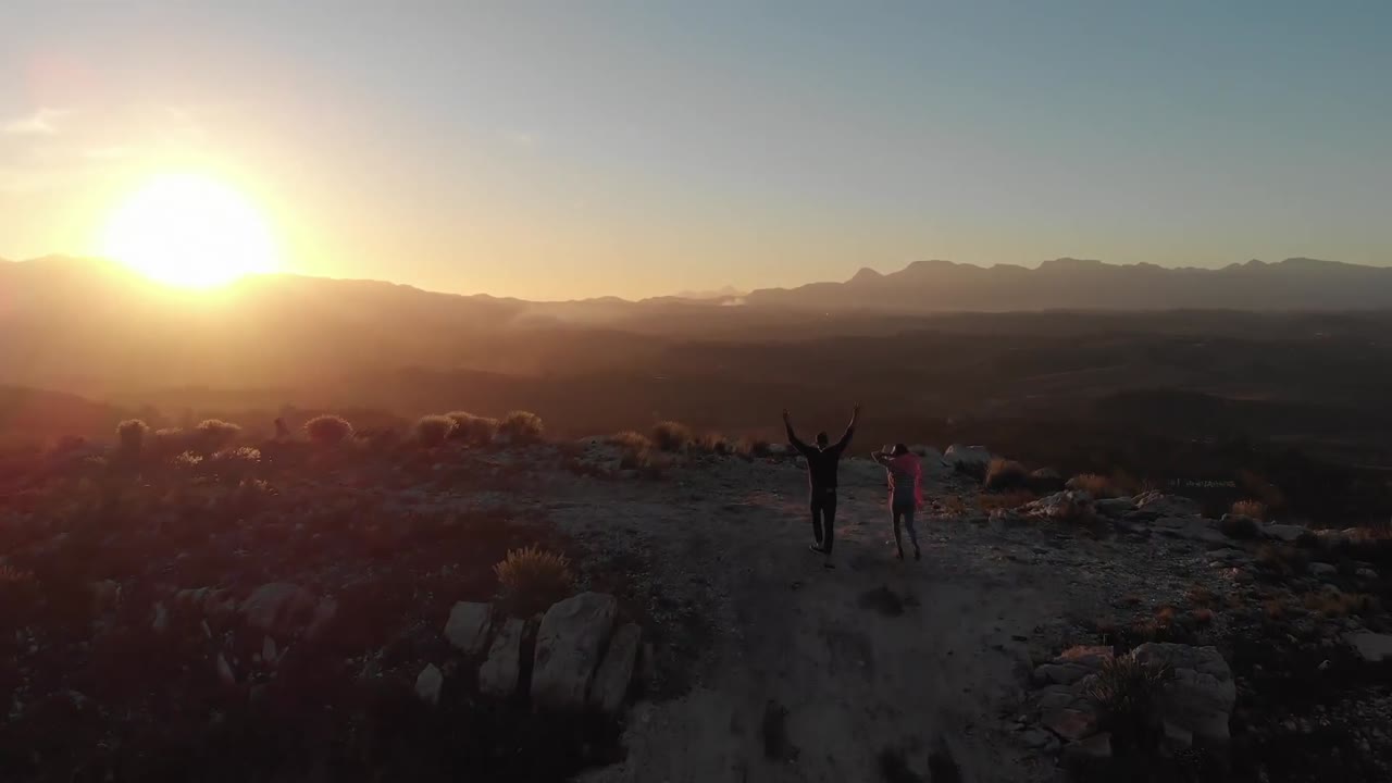 저녁에 산 꼭대기에 달리는 도로 여행에 있는 젊은 부부