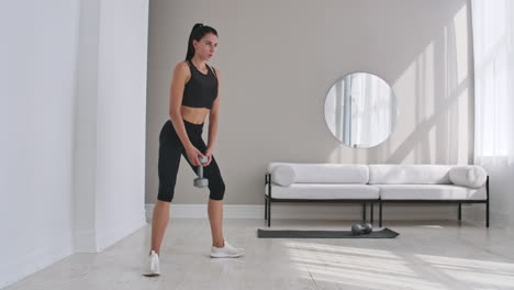 young fitness woman doing squat with dumbbells in hands.
