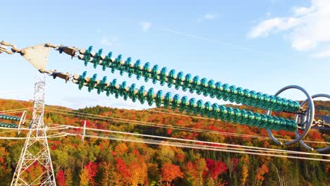 Drone-shot-of-transmission-line-towers-in-the-mountains-of-Montréal,-located-in-Québec,-Canada