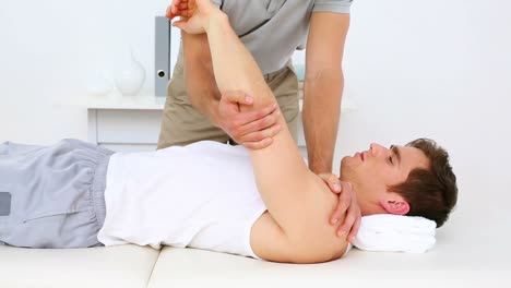 fisioterapeuta moviendo pacientes con hombro lesionado