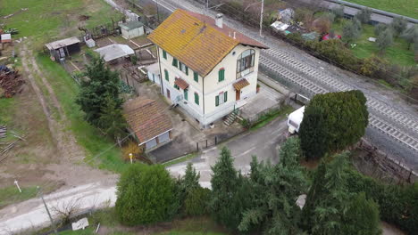 Cantoniera-house-aerial-pull-back-view-above-cultivated-landscape,-Frescobaldi-vineyard-Chianti-wine-area