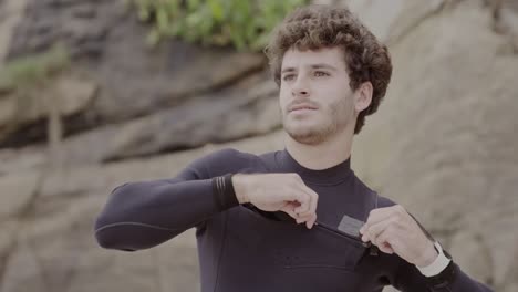 young man zipping up wetsuit