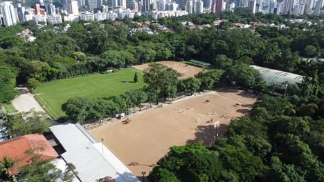 drone-filming-an-equestrian-race-with-horses-training,-beautiful-nature-and-lush-vegetation