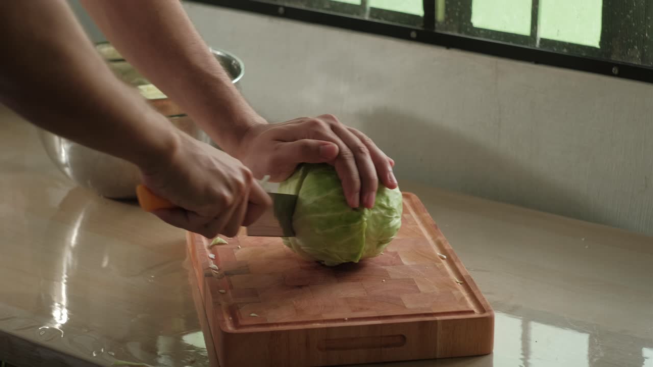 Cutting Whole Cabbage In Half On Wooden Chopping Board. - closeup shot