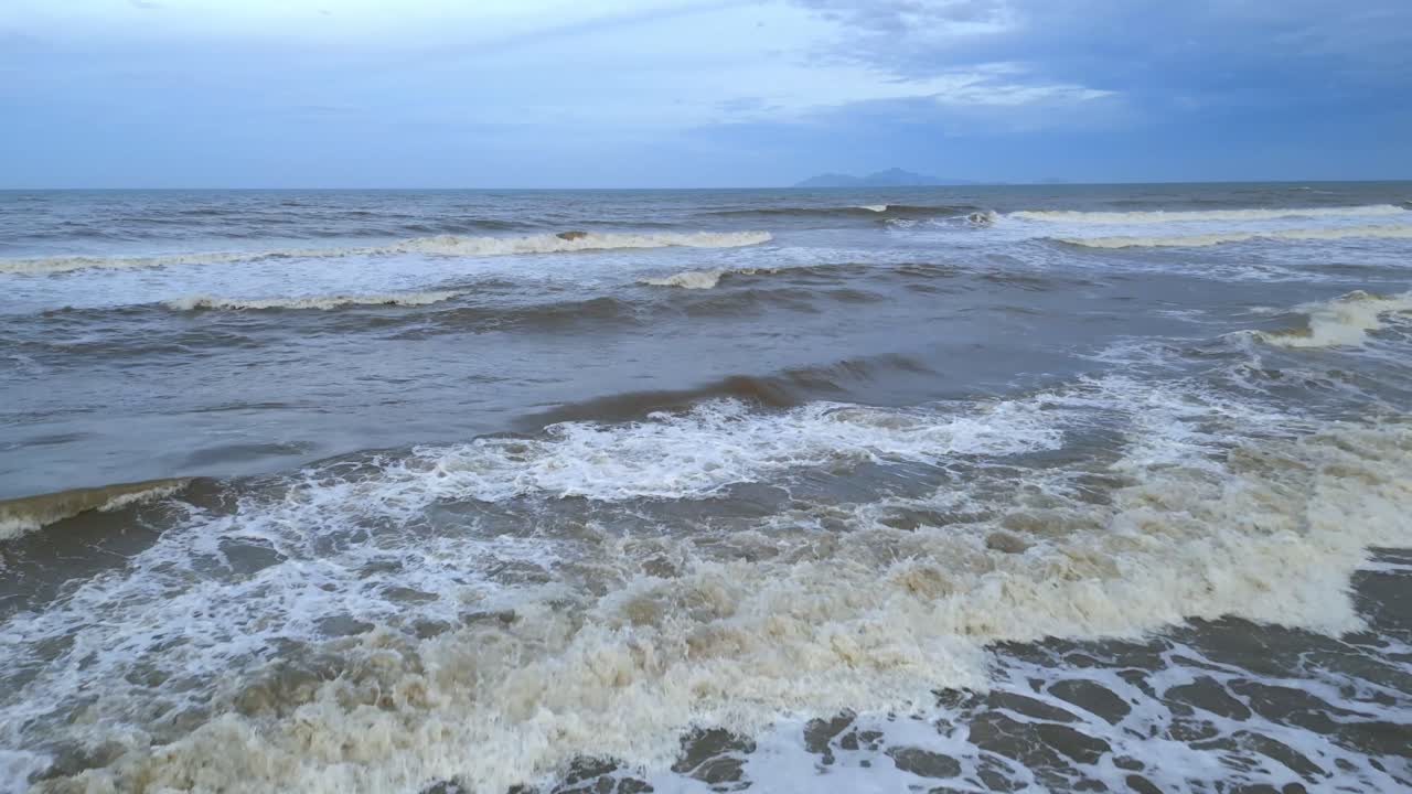 흐린 날 해변에서 부서지는 아름다운 파도